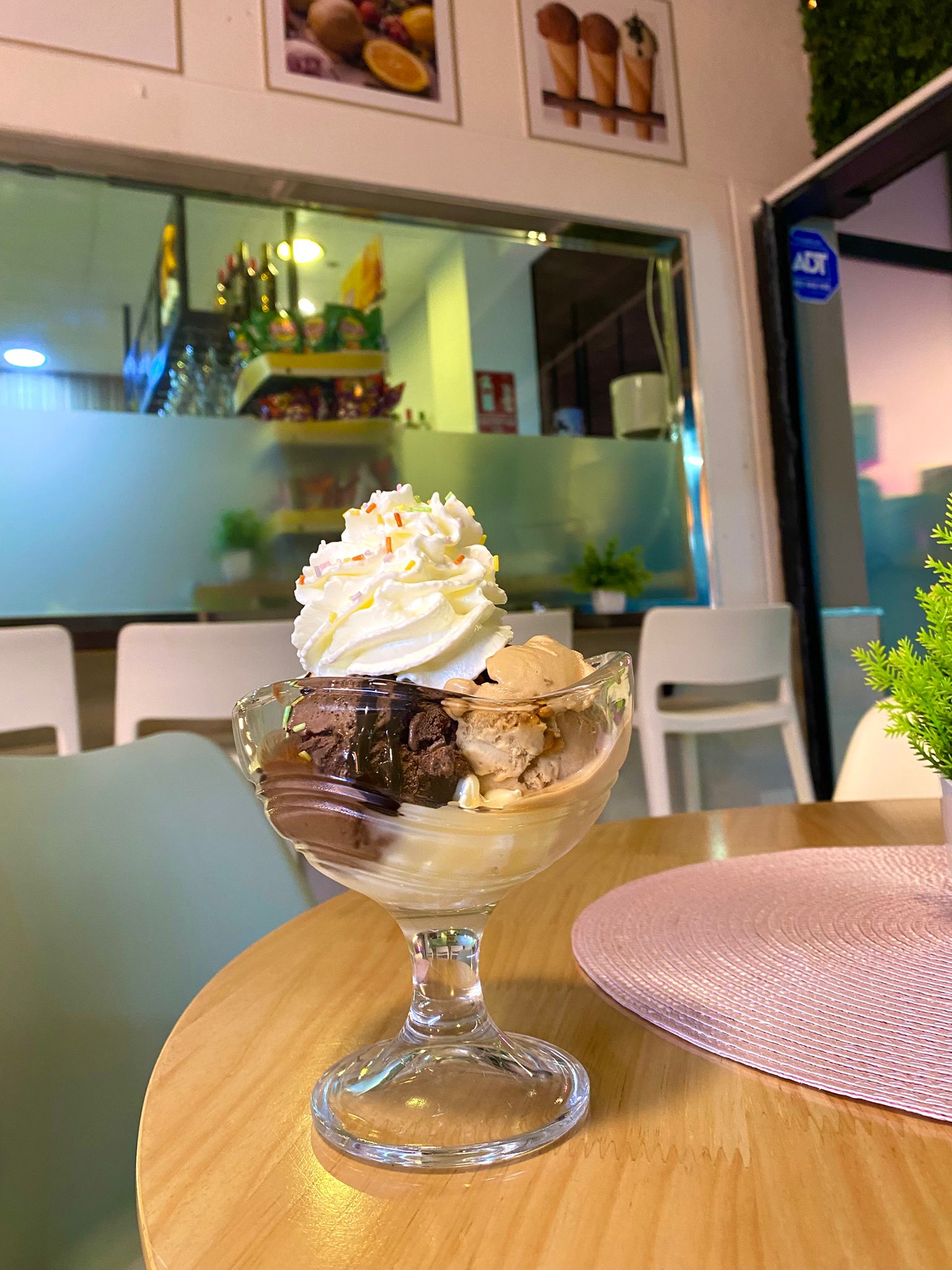 Copa de helado de chocolate y turrón con nata y fideos de colores